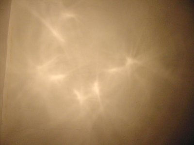 Proyección del haz a 2 m. Nótense hacia el centro las cuatro manchas luminosas correspondientes a la imagen del filamento.