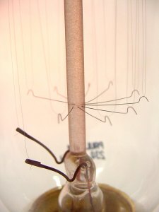 Detalle de los electrodos, el pie y la corona inferior. Nótese la capa rojiza sobre la varilla central, debida al rociado de fósforo utilizado para mejorar el grado de vacío.